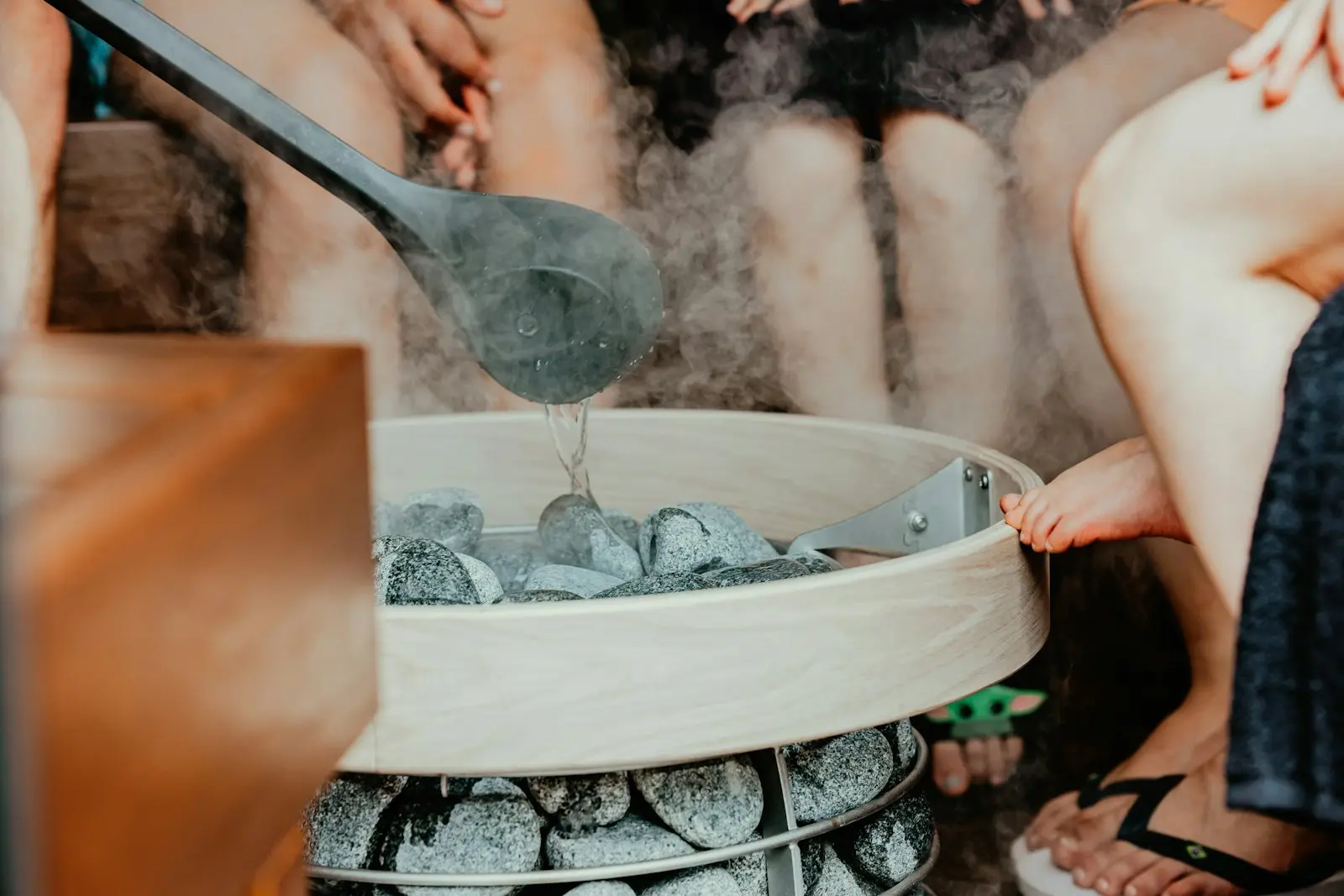 Polévání horkých kamenů vodou, z kamen stoupá pára