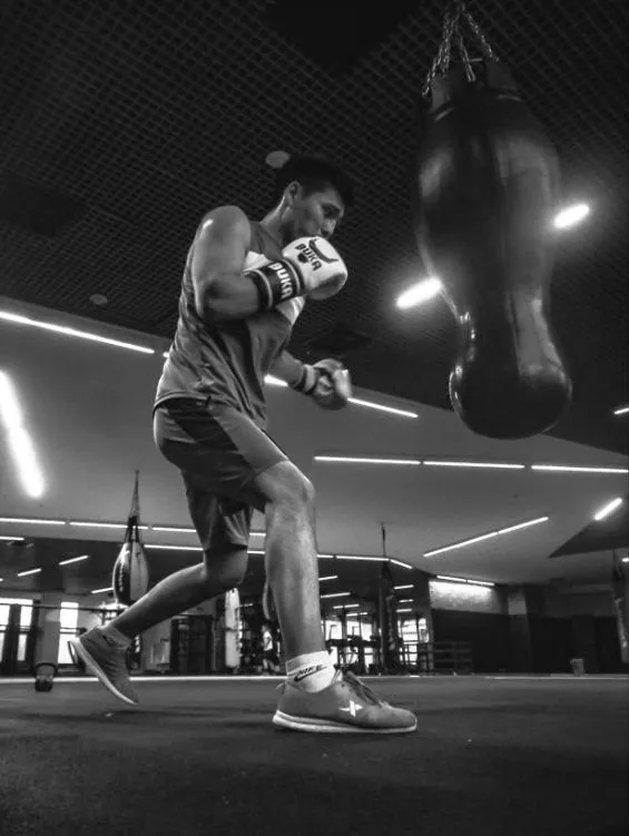 Mladý boxer při práci nohou u pytle