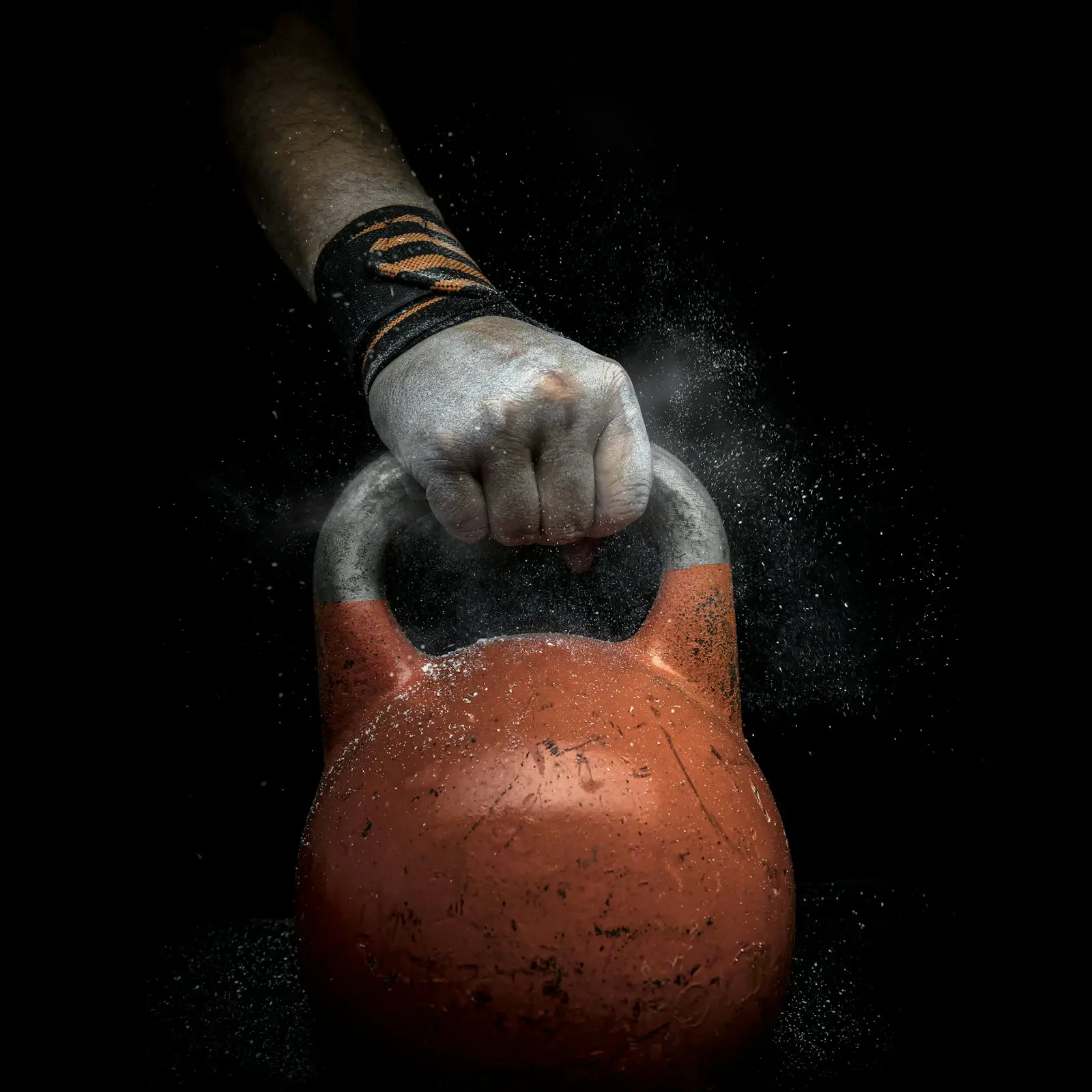 Ruka s křídou drží kettlebell